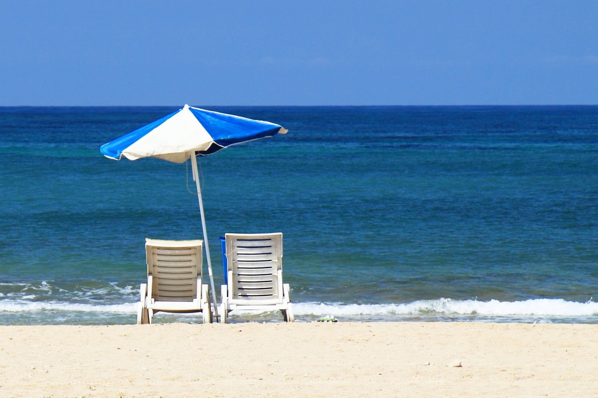 Strandstoelen en parasol aan zee